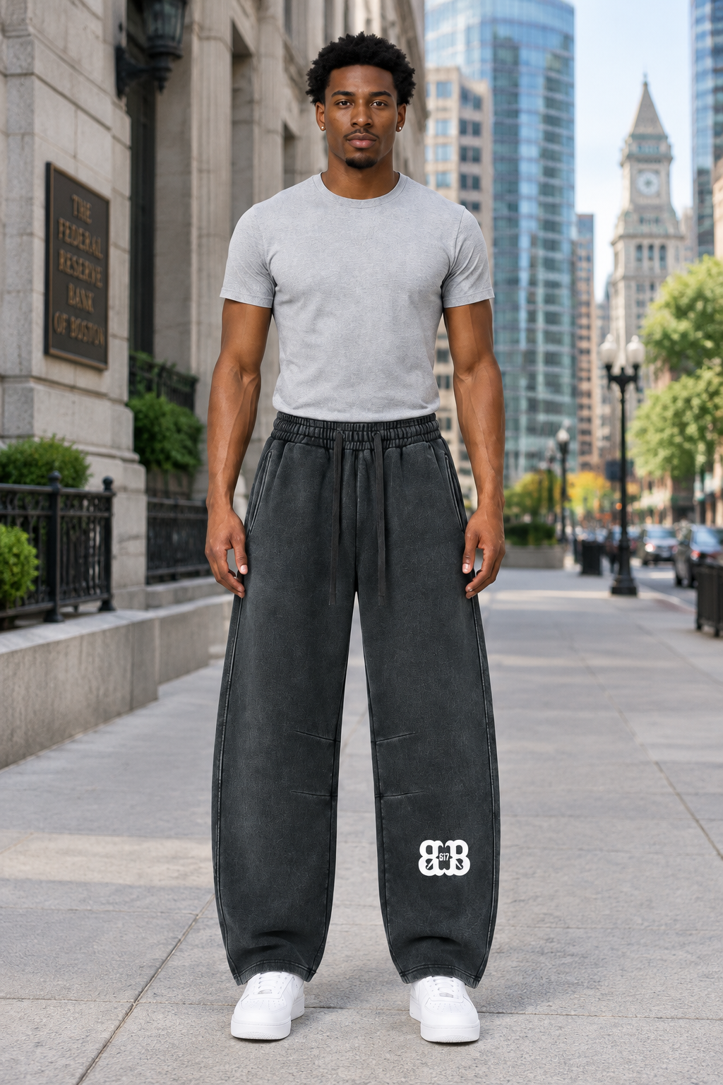 Front view of the same model wearing Bred in Boston barrel-leg sweatpants in downtown Boston